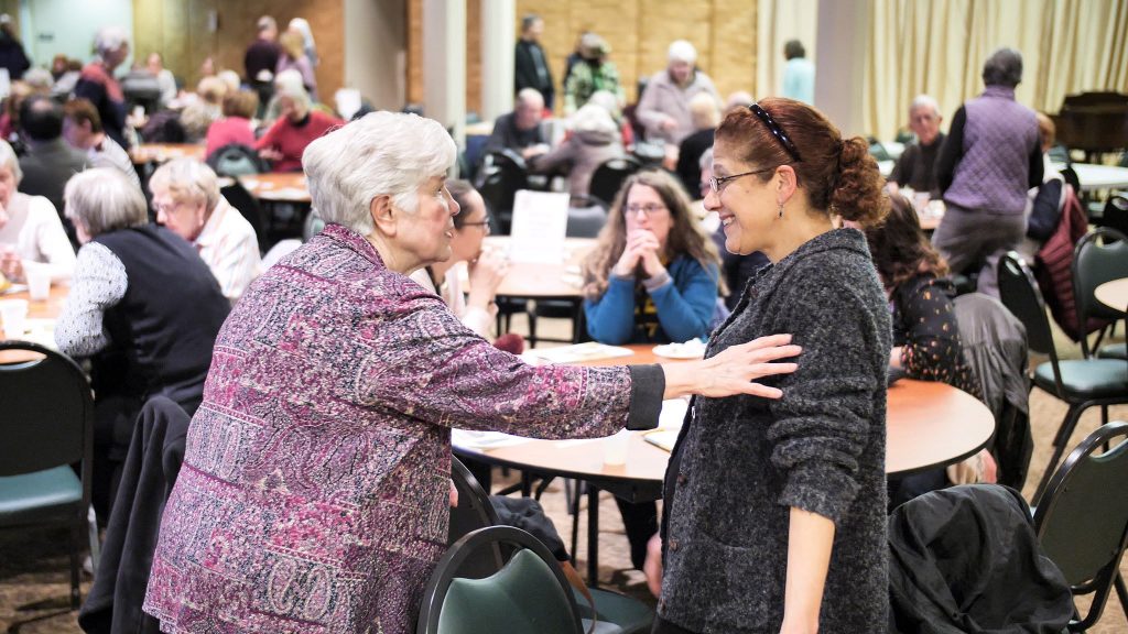 Sr. Elise is animated as she touches the shoulder of a woman at reception.