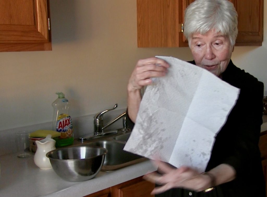 Sr. Elise displays a mostly dry paper towel in her kitchen.