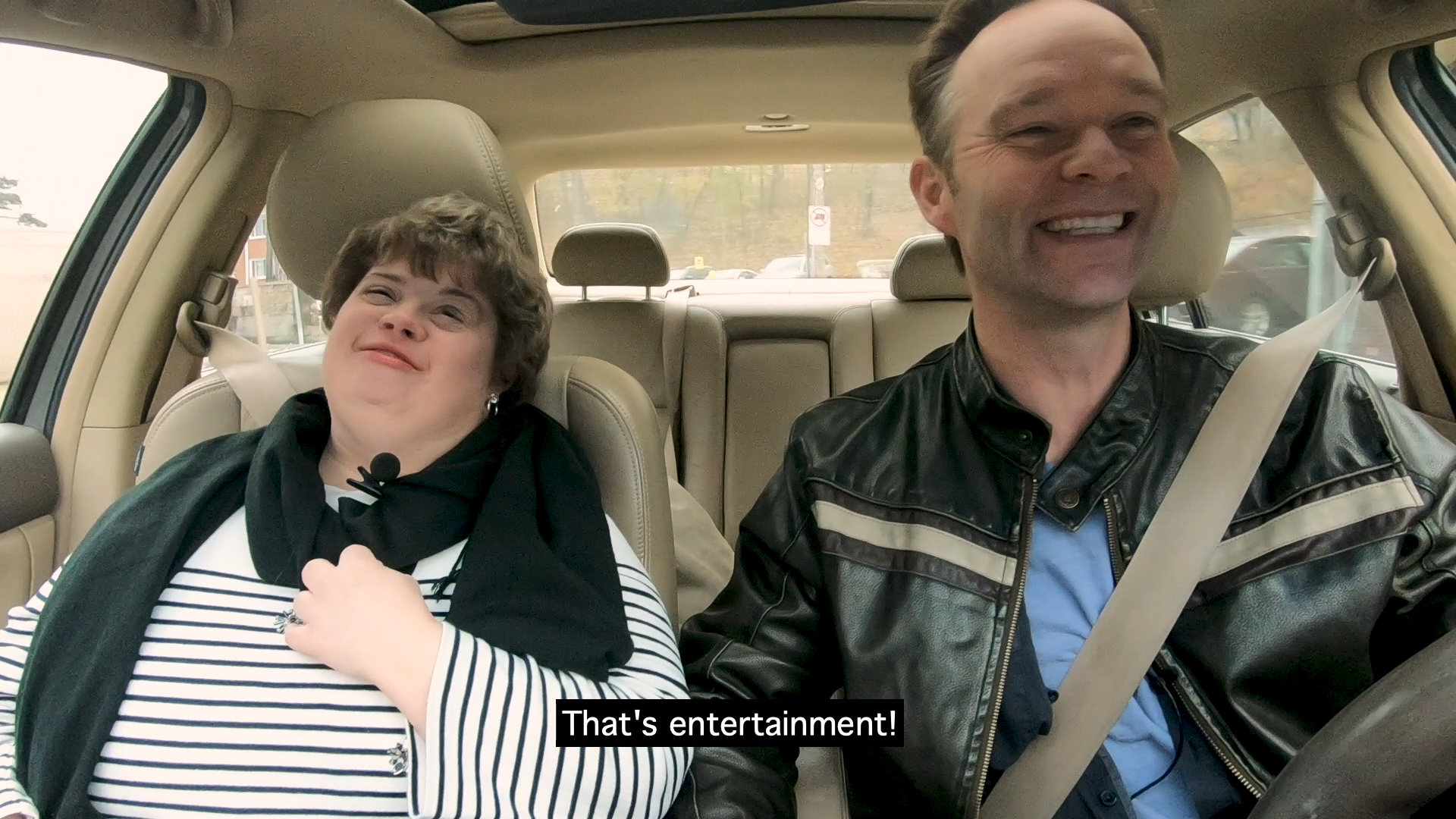 Woman and man in car singing the song That's Entertainment